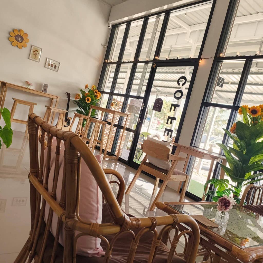 บรรยากาศโปร่งสบายภายในร้าน กระจกบานใหญ่ บาร์ไม้ และกีตาร์โปร่ง ร้านทานตะวัน Coffee & Café